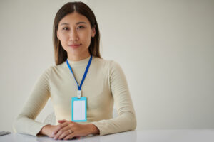 female entrepreneur with name badge sitting at office desk
